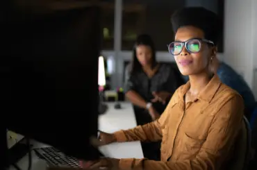 Woman in cyber sat at a computer desk