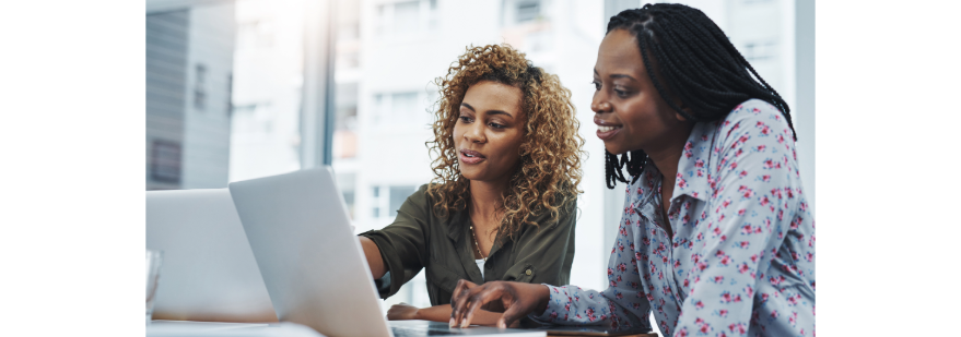 two women sat at a laptop